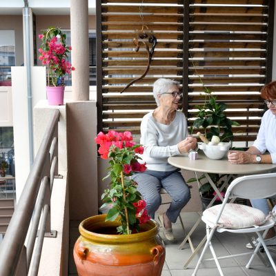 Deux séniors profitant de la terrasse de leur appartement